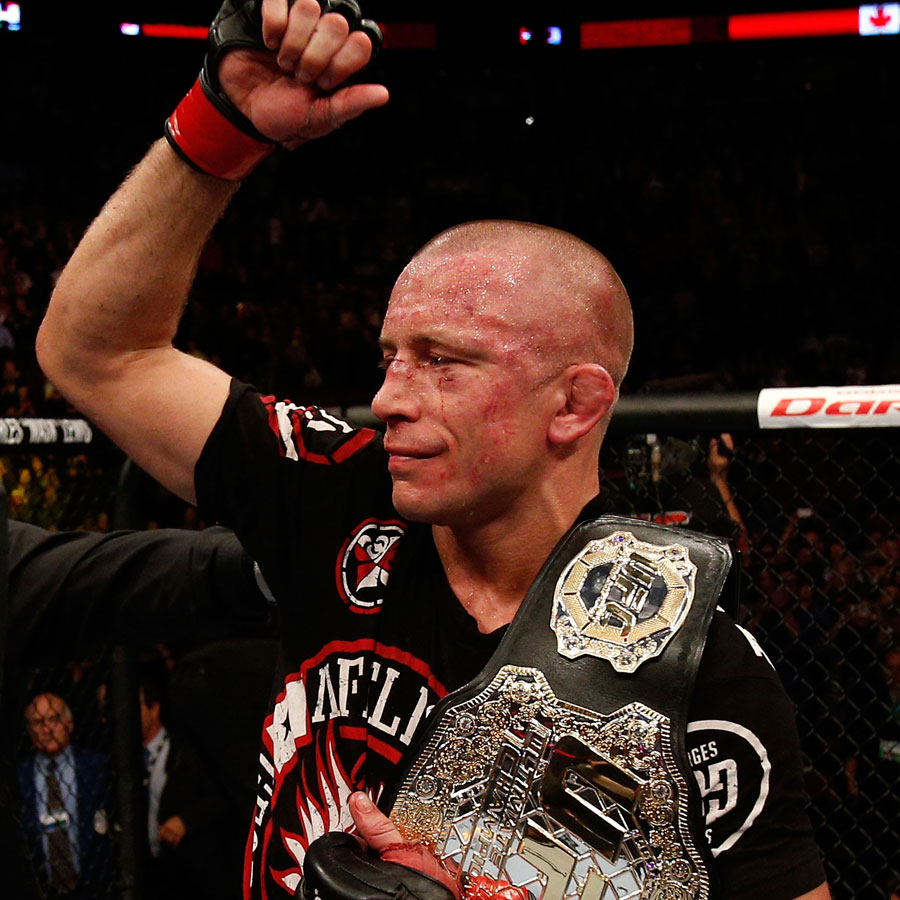 Georges St-Pierre raises his arm after fighting against Carlos Condit