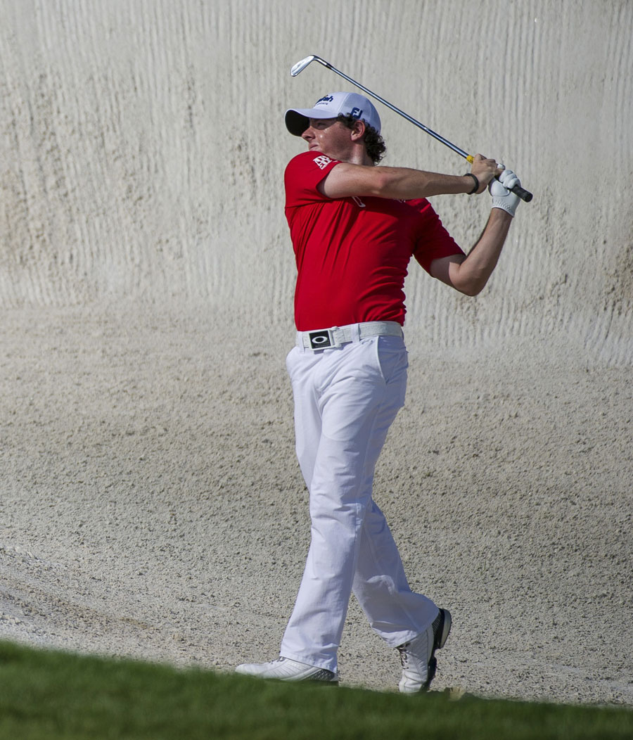Rory McIlroy plays a bunker shot on the eighth hole
