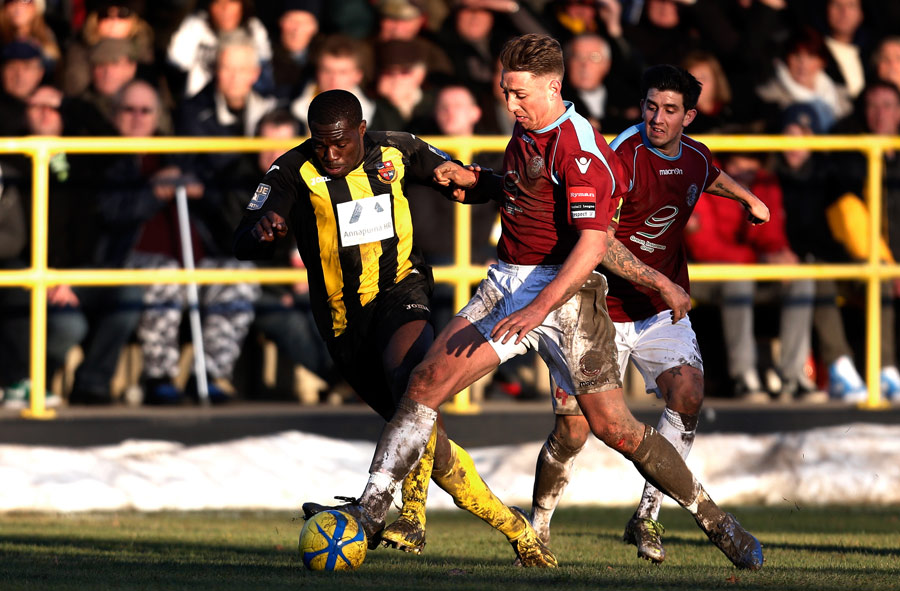 Chib Chilaka (L) of Harrogate is tackled by Jamie Crellin