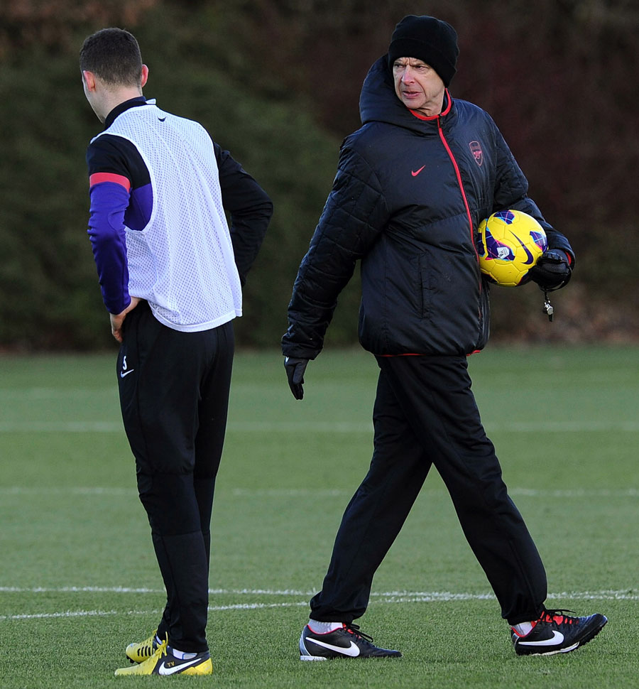 Arsene Wenger talks with Thomas Vermaelen during a training session
