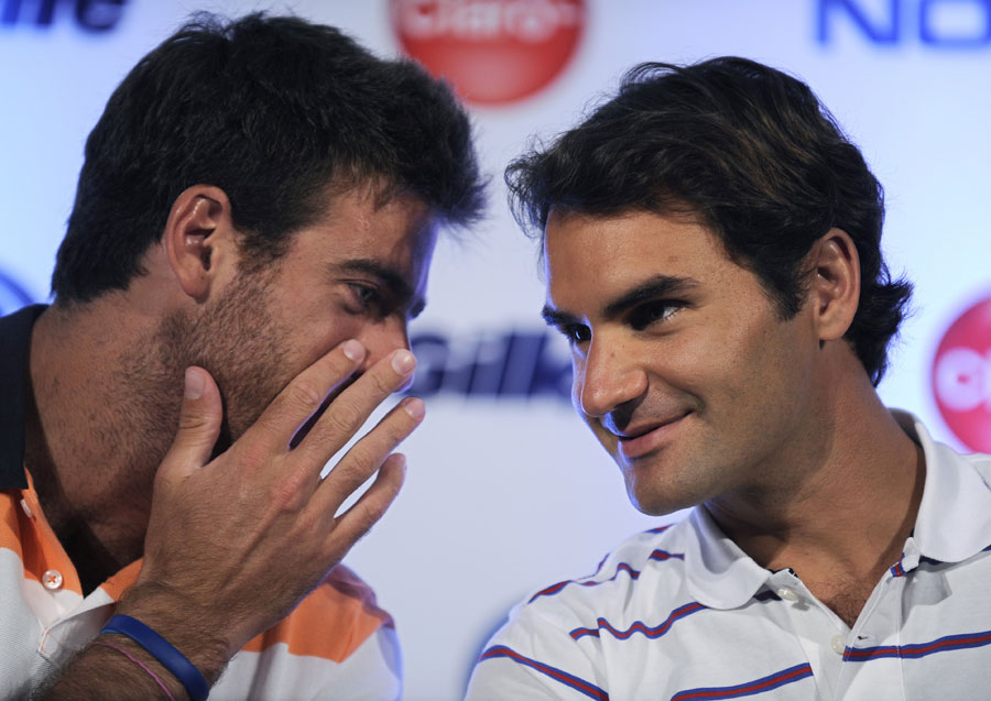 Juan Martin Del Potro whispers to Roger Federer