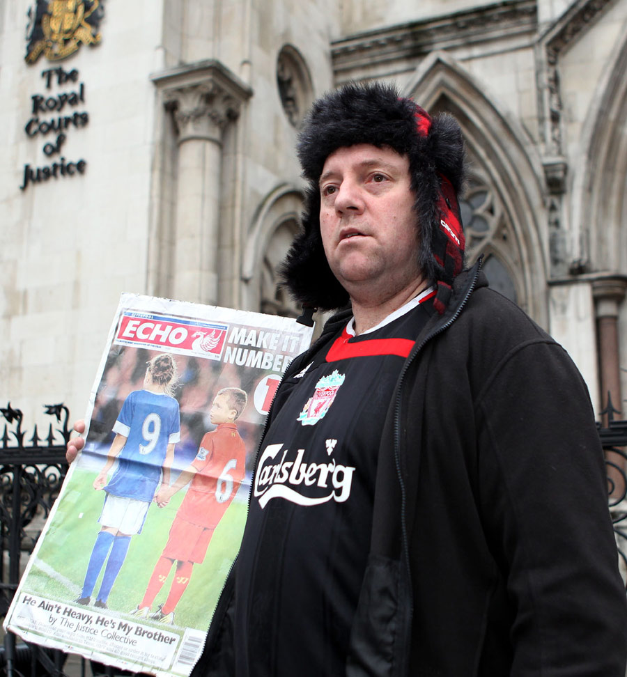 A Liverpool fan stands outside the High Court
