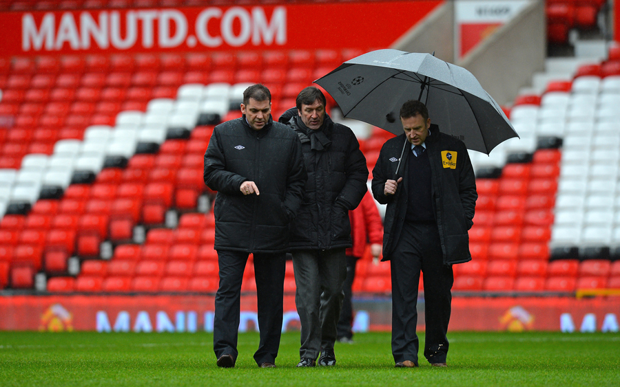 Referee Jon Moss (and assistants) inspect the Old Trafford pitch