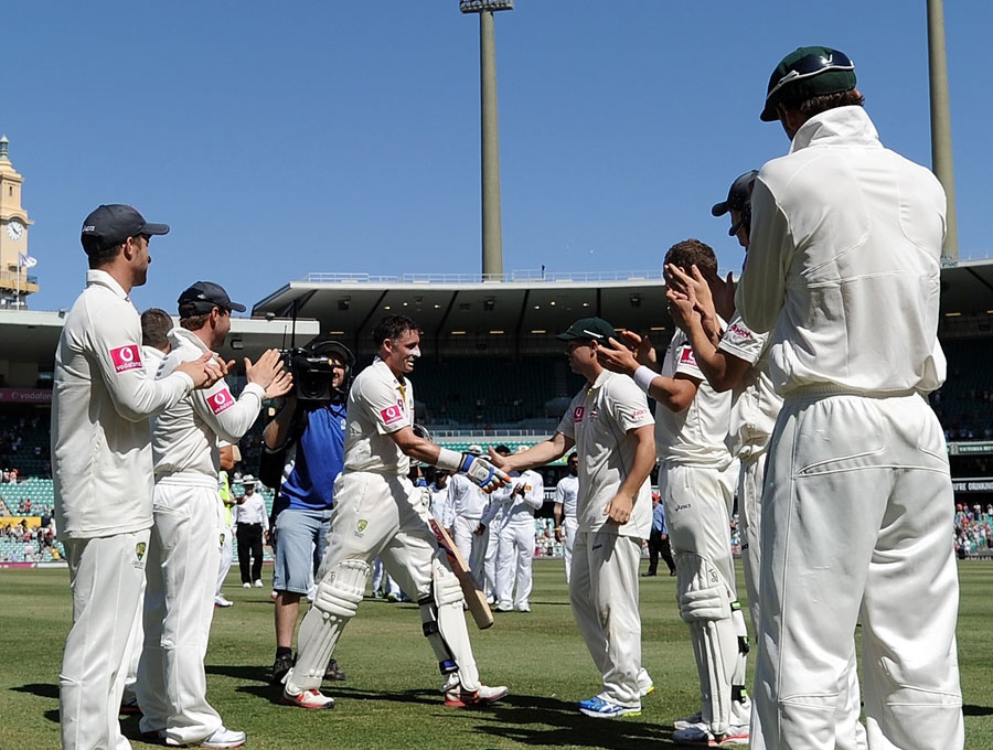 Michael Hussey shakes hands with team-mates as he walks off the field