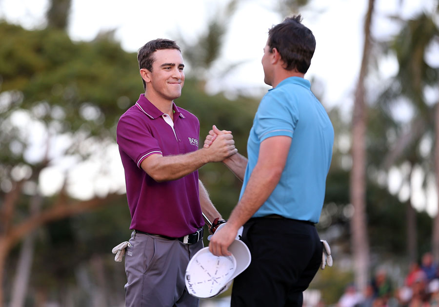 Scott Langley, left, shakes hands with Luke Guthrie on the 18th hole