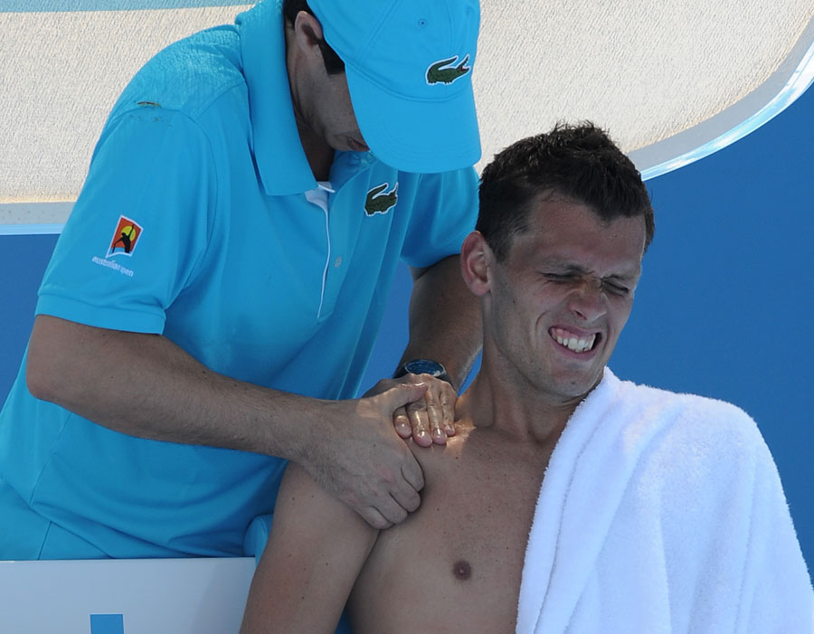 Tobias Kamke winces as he receives treatment on a shoulder injury