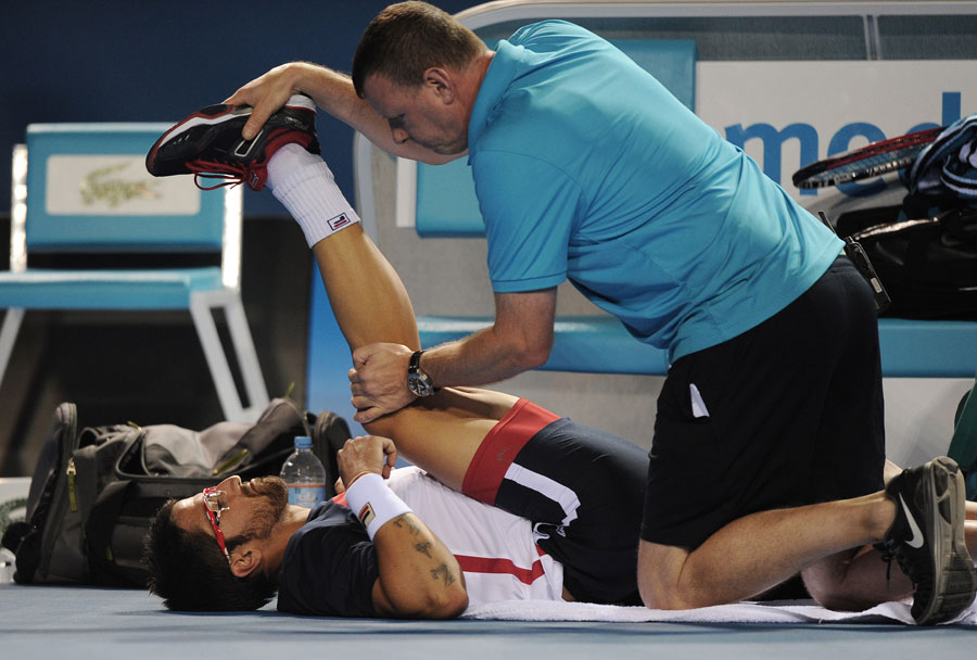 Janko Tipsarevic receives treatment on a leg injury