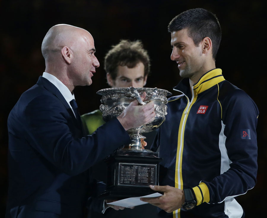Andy Murray looks on as Andre Agassi presents the trophy to Novak Djokovic