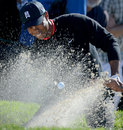 Tiger Woods hits out of the 11th green bunker