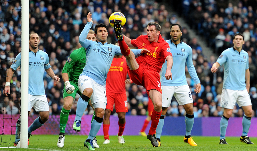 Jamie Carragher tips the ball away from Sergio Aguero