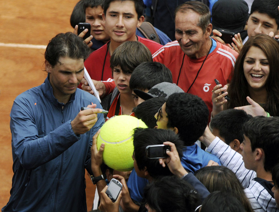 Rafael Nadal signs autographs before a training session