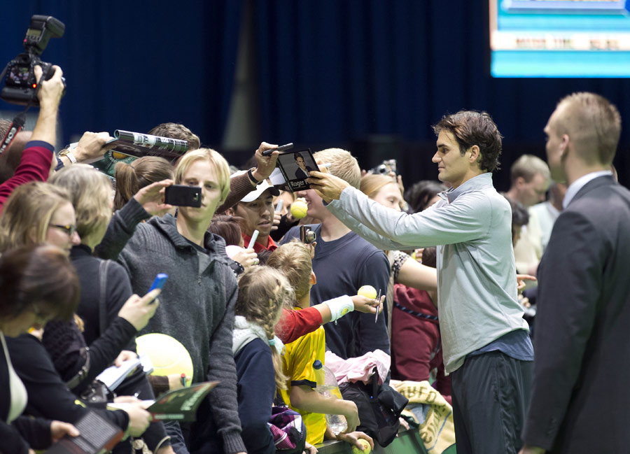 Roger Federer signs autographs after a training session 