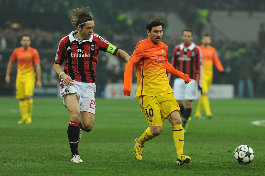 Massimo Ambrosini competes with Lionel Messi