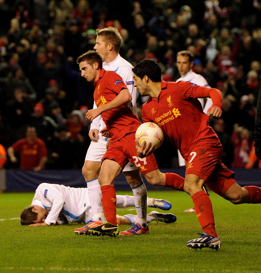Joe Allen of Liverpool celebrates his goal as Luis Suarez carries the ball out of the goal