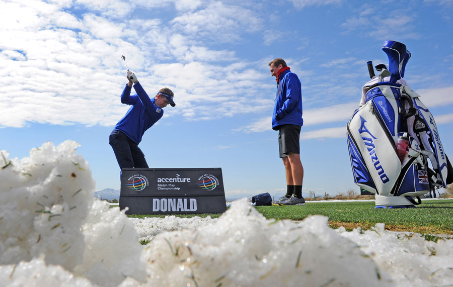 Luke Donald hits shots on the practice range as the snow clears