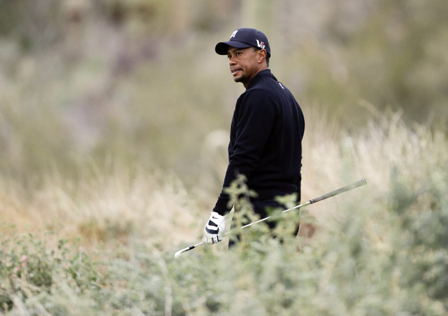 Tiger Woods reacts to a wayward approach