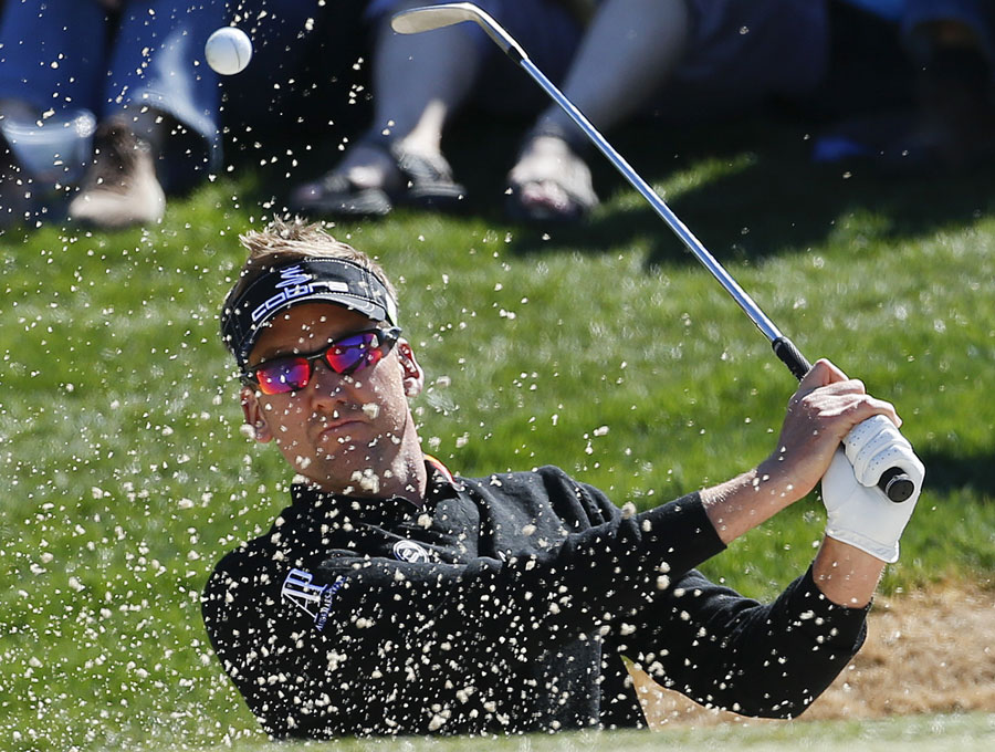 Ian Poulter hits out of a bunker
