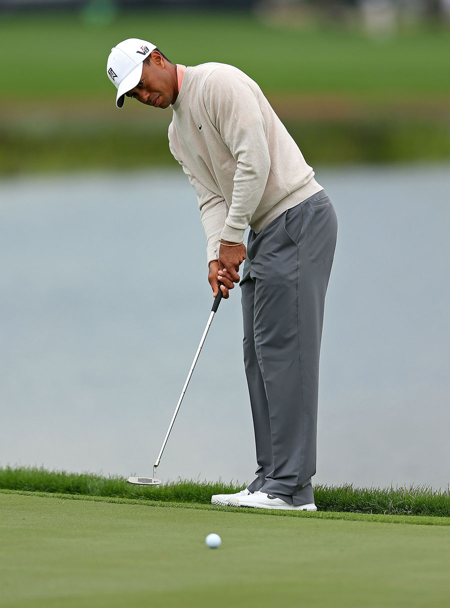 Tiger Woods putts on the fourth hole
