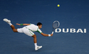 Novak Djokovic flies across court for a return