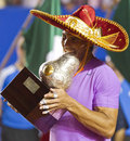 Wearing a traditional Mexican sombrero, Rafael Nadal bites the trophy