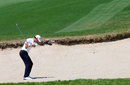Adam Scott plays a shot on the 9th hole from the bunker