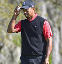 Tiger Woods tips his hat to the gallery after sinking a birdie putt