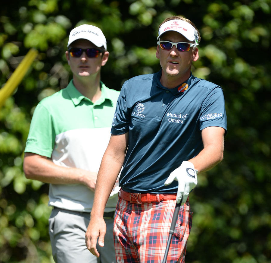 Ian Poulter tees off as Justin Rose watches