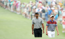 Tiger Woods and Luke Donald walk down the first