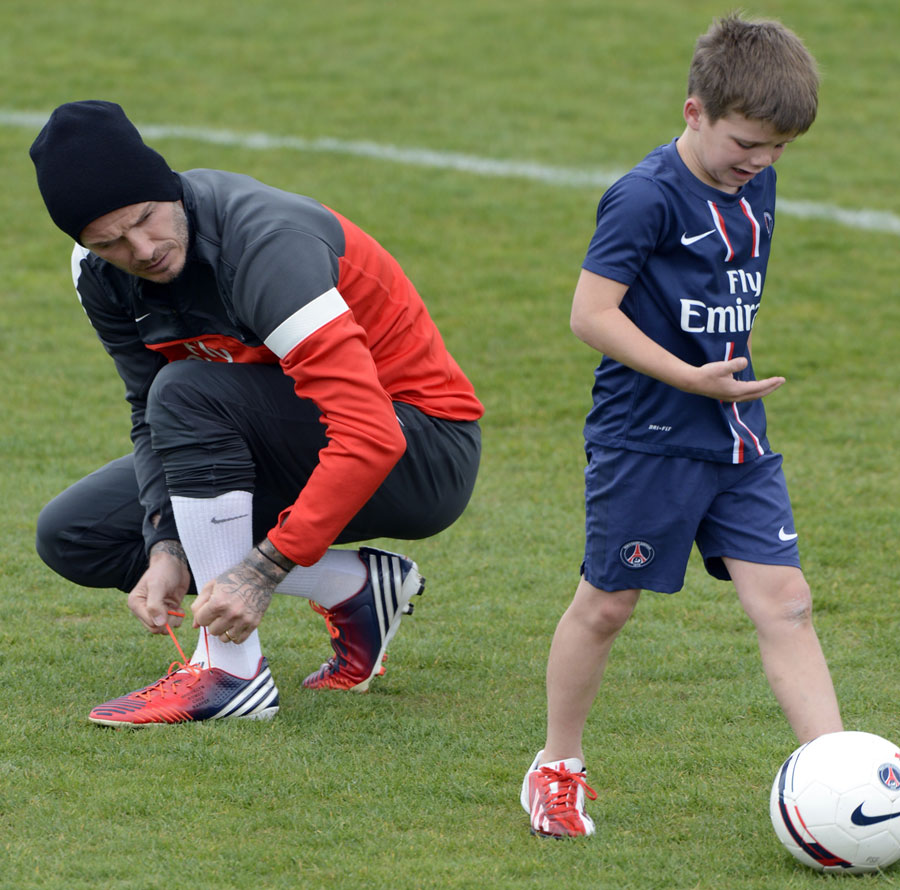 David Beckham speaks with his son Cruz as he takes part in a training session