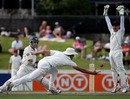 Simon Katich evades the hands of Tim McIntosh