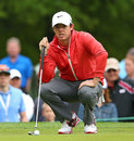 Rory McIlroy lines up a putt on the fourth hole