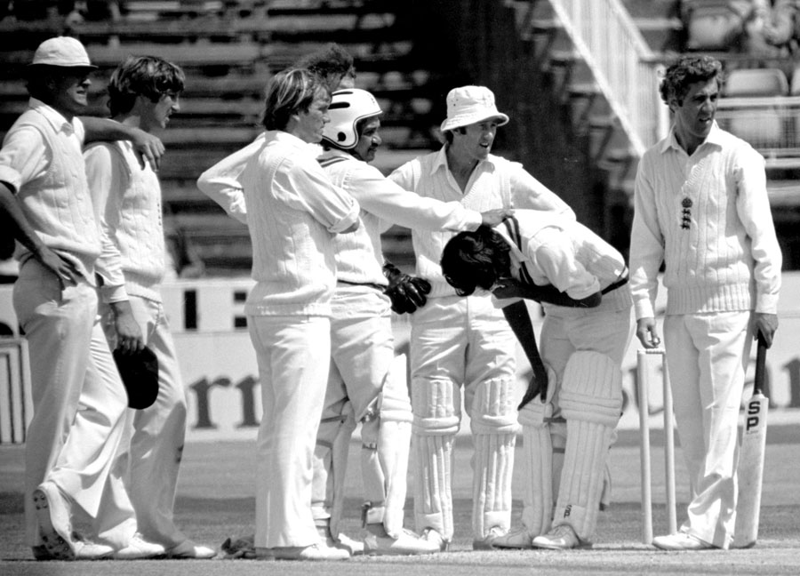 England players gather round Iqbal Qasim after he was struck by a Bob Willis bouncer