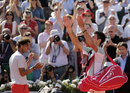 Novak Djokovic waves to the crowd as Rafael Nadal applauds
