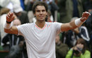 Rafael Nadal raises his arms in the air