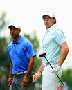 Tiger Woods and Rory McIlroy look on