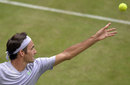 Roger Federer throws the ball in the air