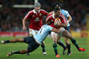 Rob Kearney is held back by Peter Betham