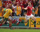 The Lions' George North gestures to Australia's Will Genia on his way to a try