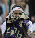 Roger Federer wipes his face with a towel
