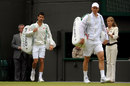 Novak Djokovic walks on court behind Tomas Berdych