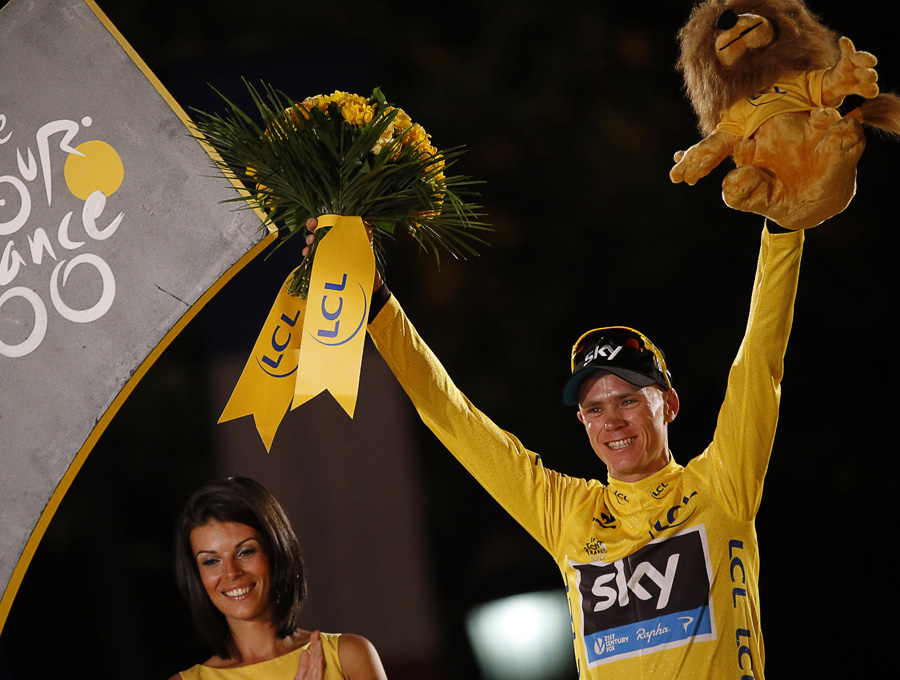 Chris Froome stands on the podium