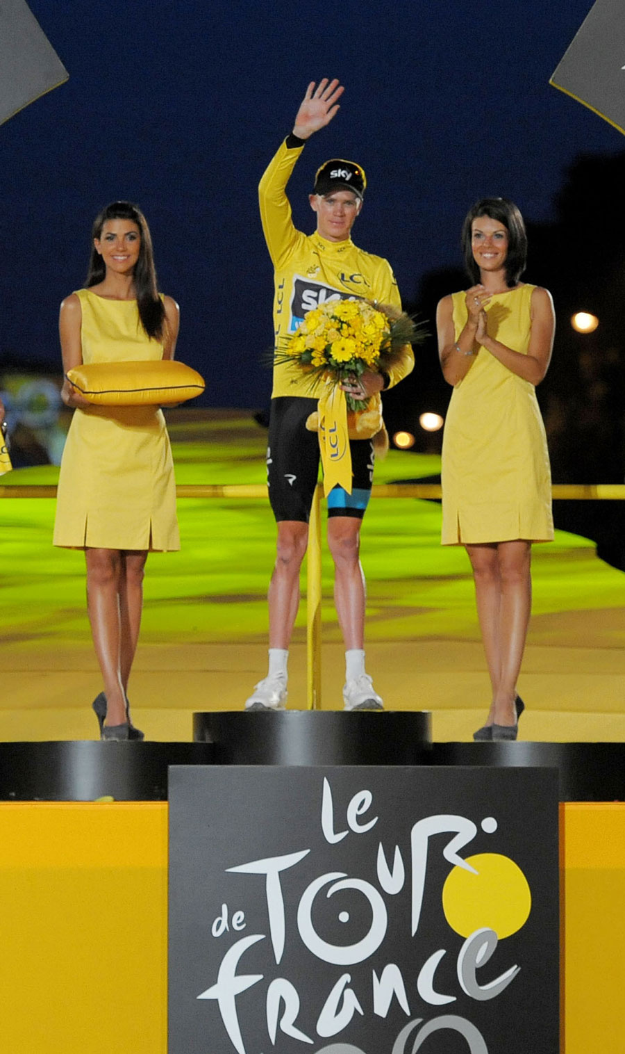 Chris Froome waves on the podium