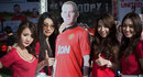 Thai promotion models stand next to a cut-out of Wayne Rooney
