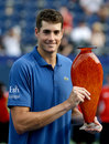 John Isner poses with the trophy after defeating Kevin Anderson