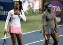 Venus Williams and Serena Williams laugh during an exhibition doubles match