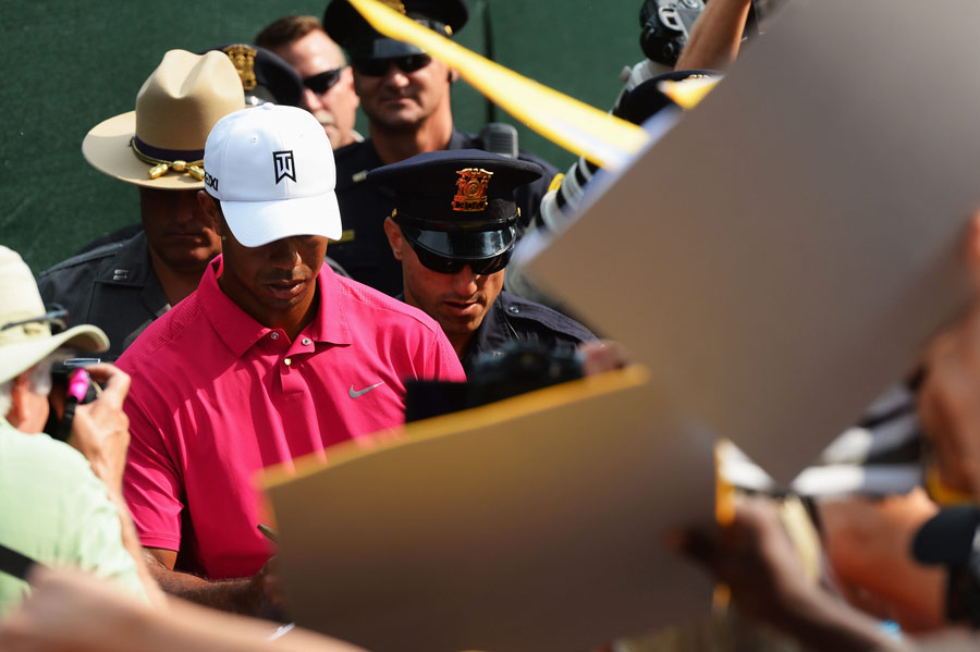 Tiger Woods signs autographs during a practice round
