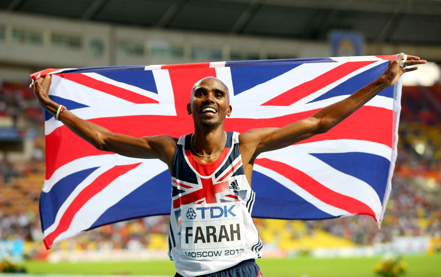 Mo Farah holds the British flag above his shoulders after his win in the 5000m
