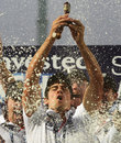 Alastair Cook lifts the Ashes urn in a sea of champagne