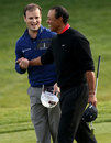 Zach Johnson and Tiger Woods share a joke on the final green