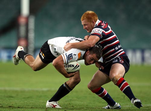 Rocky Trimarchi of the Tigers is tackled by Ben Jones of the Roosters 